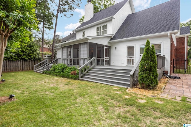 back of house featuring fence, a chimney, a sunroom, and roof with shingles