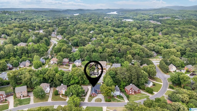 drone / aerial view featuring a residential view, a wooded view, and a mountain view