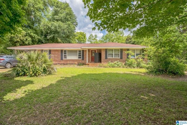 ranch-style home featuring brick siding and a front lawn