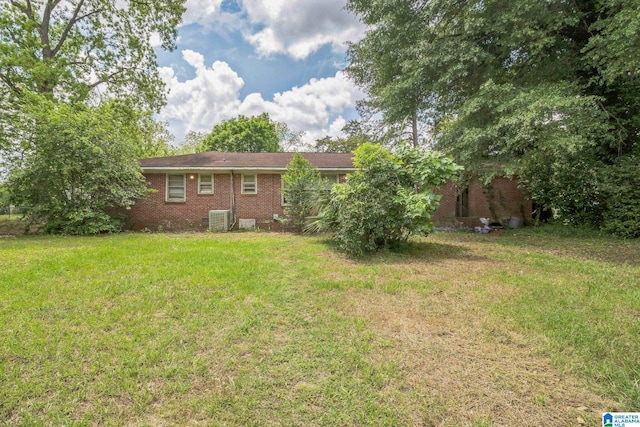back of property with a lawn and brick siding