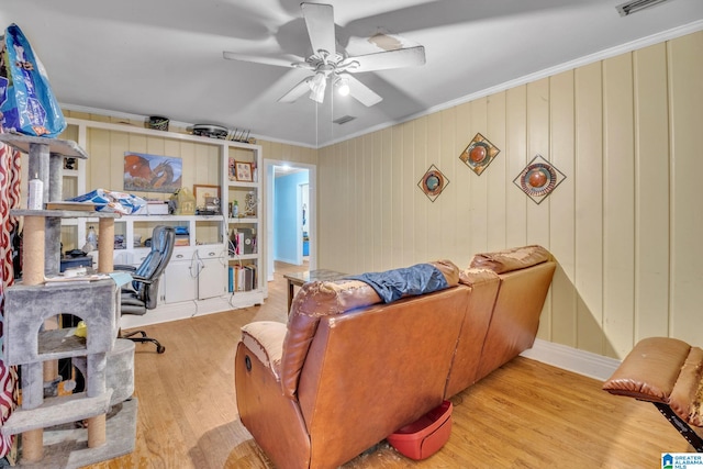 interior space featuring crown molding, a ceiling fan, wood finished floors, and visible vents