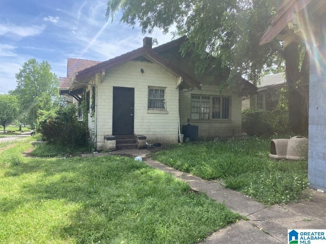 view of front facade with entry steps and a front lawn