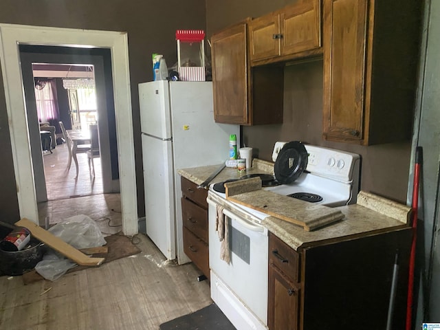 kitchen featuring white appliances, light countertops, and brown cabinets