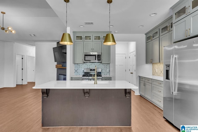 kitchen featuring light wood-style floors, light countertops, decorative backsplash, and stainless steel appliances