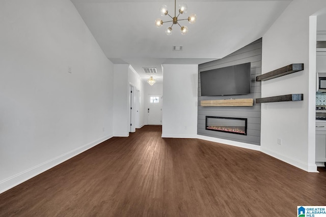 unfurnished living room featuring an inviting chandelier, a large fireplace, wood finished floors, and visible vents