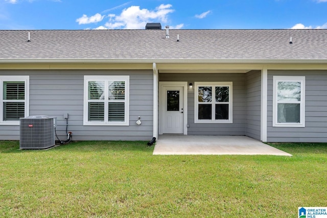 back of property with a lawn, a patio, a shingled roof, and cooling unit