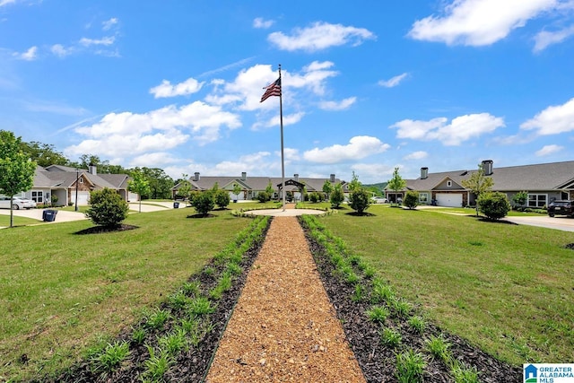 view of yard with a residential view, concrete driveway, and a garage