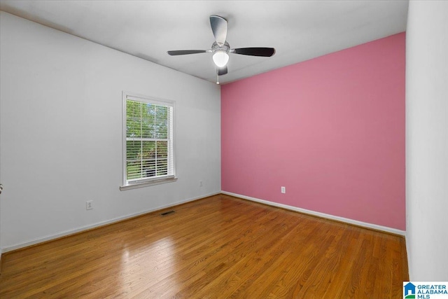 empty room featuring baseboards, ceiling fan, and wood finished floors