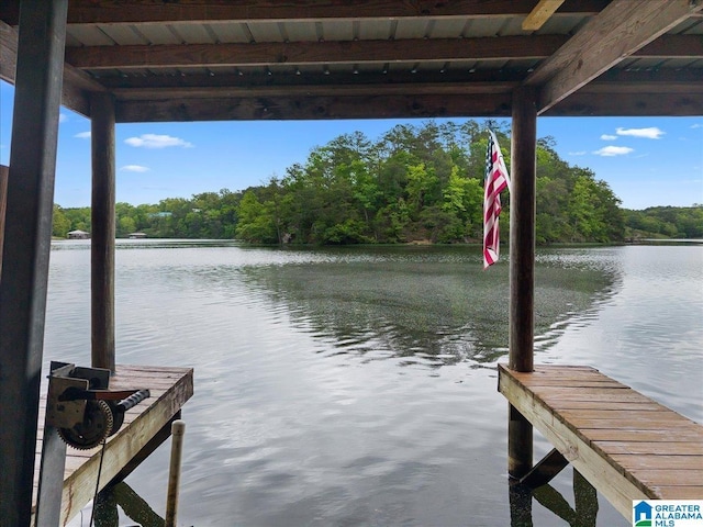 dock area featuring a water view and a wooded view