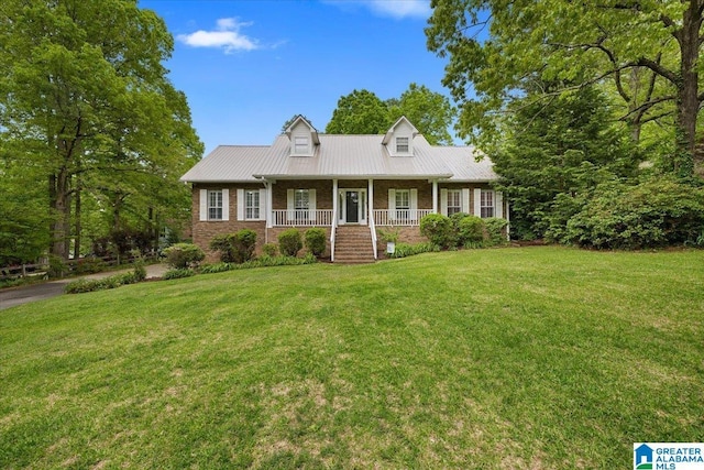 cape cod home with brick siding, a front lawn, covered porch, and metal roof