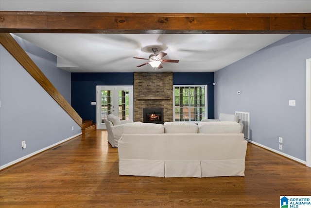 living area with baseboards, a fireplace, a ceiling fan, and wood finished floors