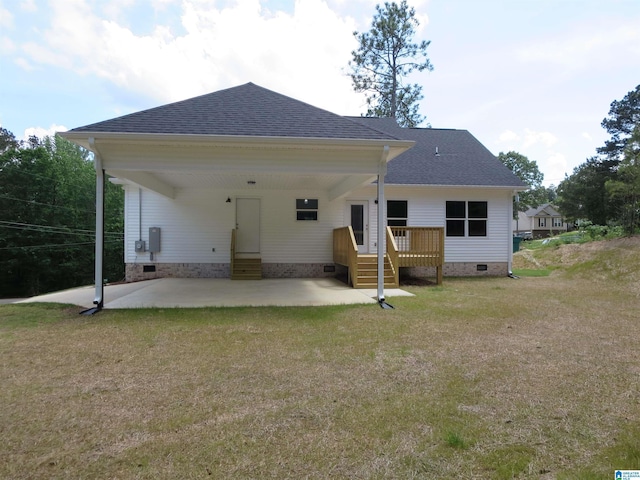 back of property with roof with shingles, a yard, crawl space, and a carport