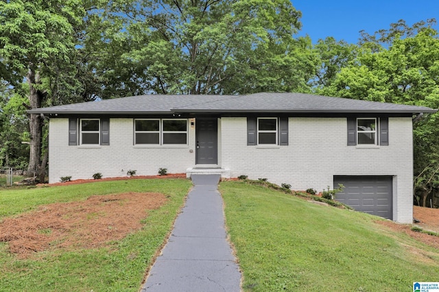 ranch-style house featuring driveway, brick siding, a front lawn, an attached garage, and a shingled roof