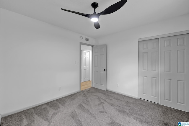 unfurnished bedroom with carpet floors, visible vents, a closet, baseboards, and a ceiling fan