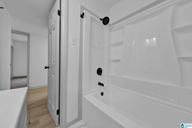 full bath with vanity, shower / bathing tub combination, baseboards, and wood finished floors