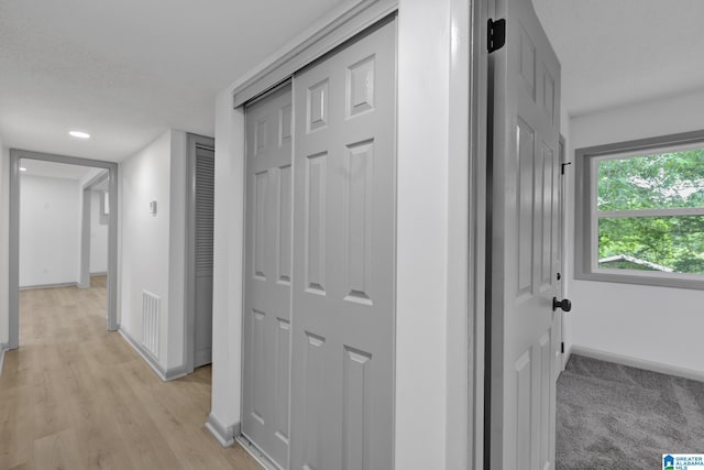 corridor with baseboards, recessed lighting, light wood-style floors, and visible vents