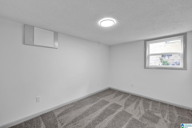below grade area featuring baseboards, carpet flooring, and a textured ceiling