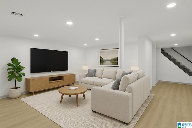 living area with recessed lighting, baseboards, light wood-type flooring, visible vents, and stairway