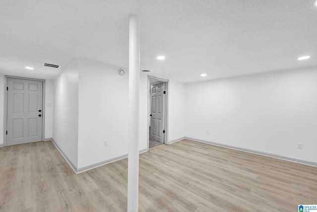 finished basement featuring visible vents, recessed lighting, baseboards, and light wood-type flooring