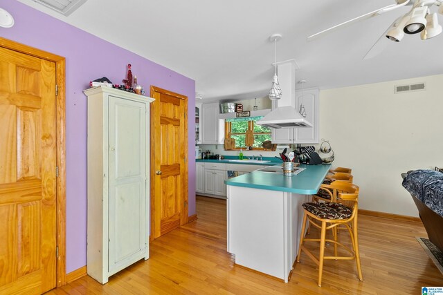 323 Taylor Rd, Remlap, AL 35133 - kitchen with a peninsula, a kitchen bar, white cabinetry, and light wood finished floors