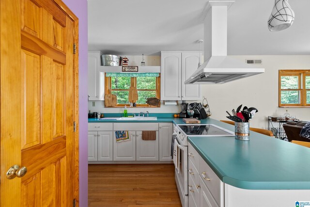 323 Taylor Rd, Remlap, AL 35133 - kitchen featuring white electric range oven, island range hood, light wood-style flooring, white cabinetry, and a sink