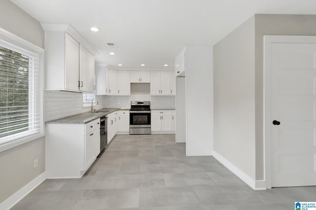 2636 20th Pl, Birmingham, AL 35208 - kitchen featuring stainless steel electric range oven, tasteful backsplash, a sink, baseboards, and dishwashing machine