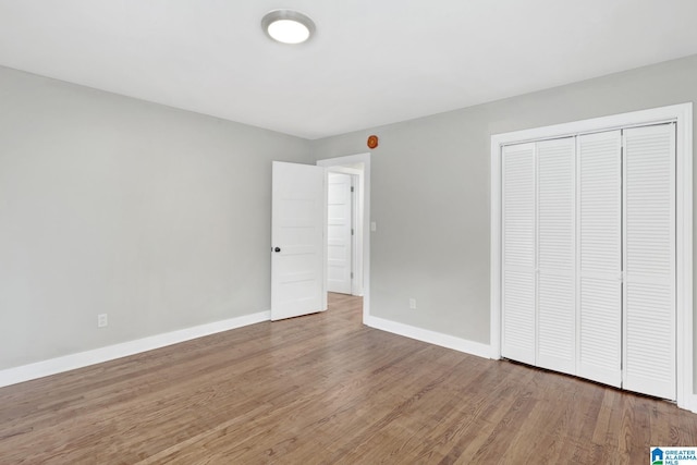 2636 20th Pl, Birmingham, AL 35208 - unfurnished bedroom featuring baseboards, a closet, and wood finished floors
