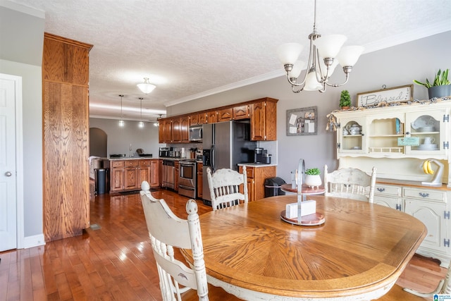 145 Cameron Ct, Alexandria, AL 36250 - dining room featuring ornamental molding, a textured ceiling, dark wood-style flooring, and a chandelier