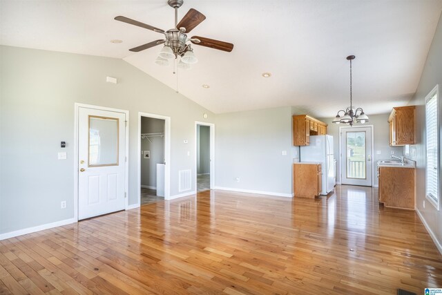 145 Cameron Ct, Alexandria, AL 36250 - unfurnished living room featuring light wood-type flooring, a sink, baseboards, ceiling fan with notable chandelier, and lofted ceiling