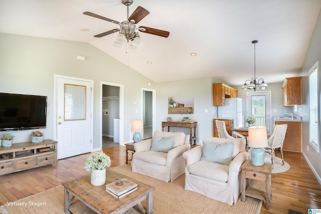 145 Cameron Ct, Alexandria, AL 36250 - living room with baseboards, light wood finished floors, ceiling fan with notable chandelier, and vaulted ceiling