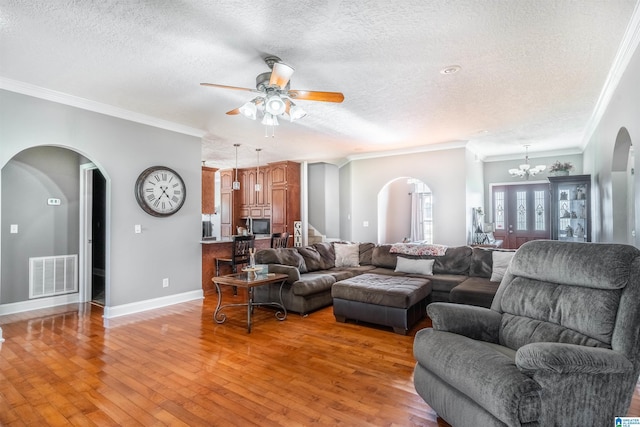 145 Cameron Ct, Alexandria, AL 36250 - living room featuring crown molding, arched walkways, a textured ceiling, and visible vents
