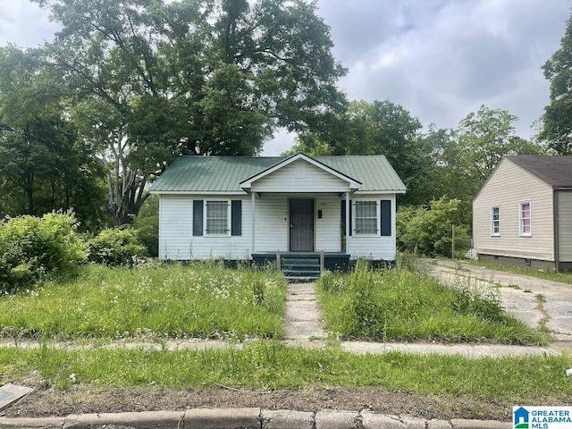 bungalow-style house with covered porch and metal roof