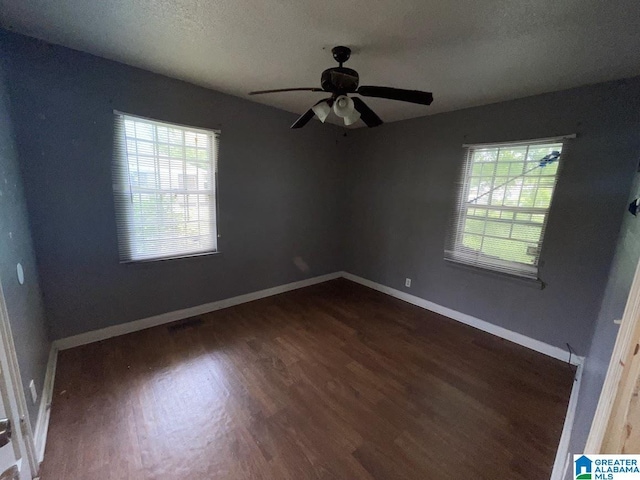 empty room with a healthy amount of sunlight, a ceiling fan, and wood finished floors
