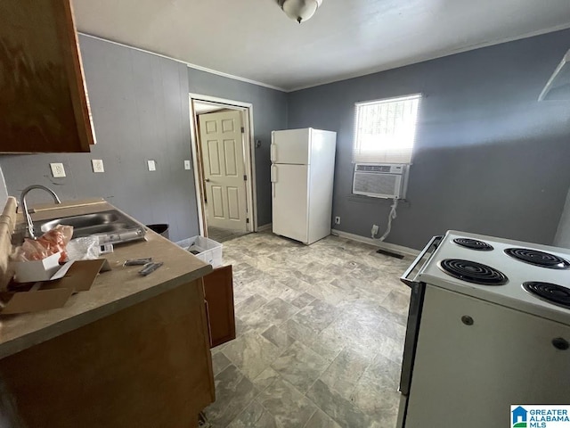 kitchen with stone finish flooring, a sink, baseboards, cooling unit, and white appliances