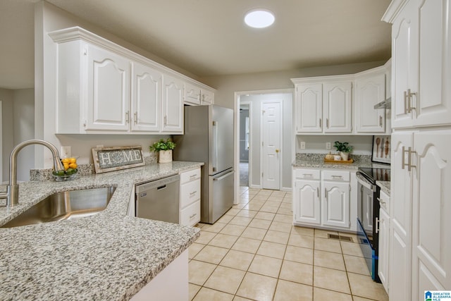 kitchen with white cabinets, stainless steel appliances, light tile patterned floors, and a sink