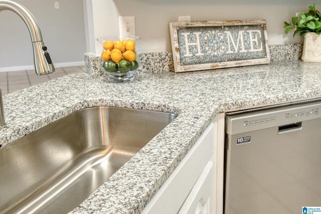 interior details featuring stainless steel dishwasher and a sink