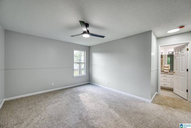 unfurnished bedroom featuring connected bathroom, ceiling fan, light carpet, a textured ceiling, and baseboards