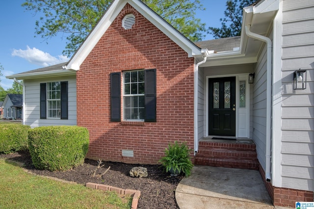 view of exterior entry featuring brick siding