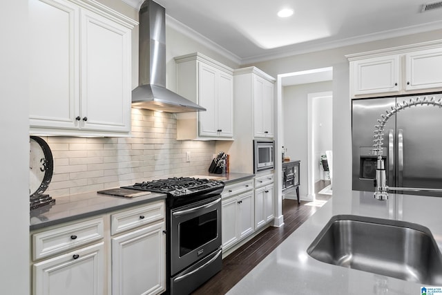 4000 Dunemere Ln, Hoover, AL 35226 - kitchen with wall chimney exhaust hood, stainless steel appliances, ornamental molding, dark wood-style floors, and white cabinetry