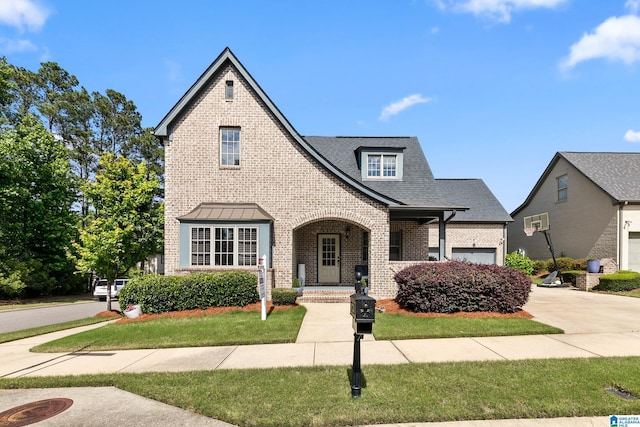 4000 Dunemere Ln, Hoover, AL 35226 - tudor-style house with brick siding, a front yard, an attached garage, concrete driveway, and a shingled roof