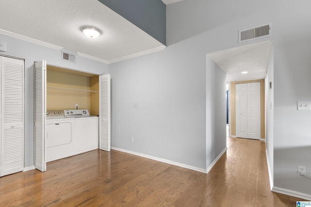 washroom with separate washer and dryer, laundry area, visible vents, and wood finished floors