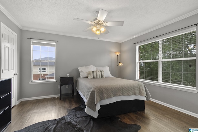 bedroom featuring baseboards, a textured ceiling, ornamental molding, and wood finished floors