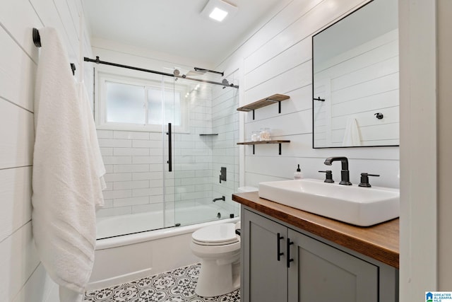 full bath with toilet, tile patterned floors, shower / bath combination with glass door, and vanity