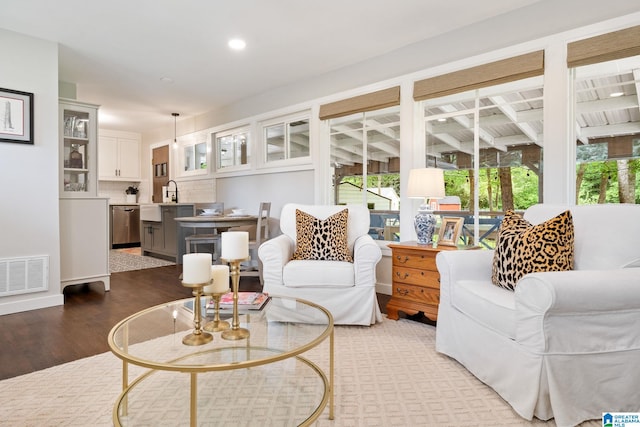 living area with recessed lighting, visible vents, a healthy amount of sunlight, and wood finished floors