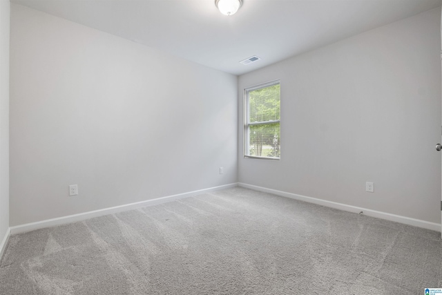 empty room with baseboards, carpet flooring, and visible vents