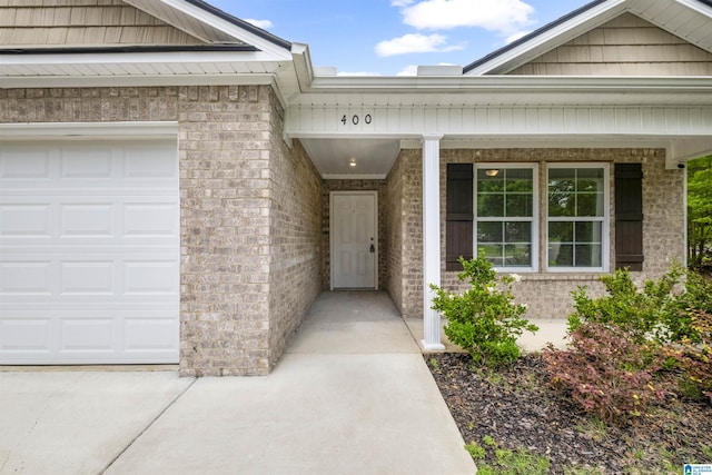 property entrance featuring a porch and brick siding