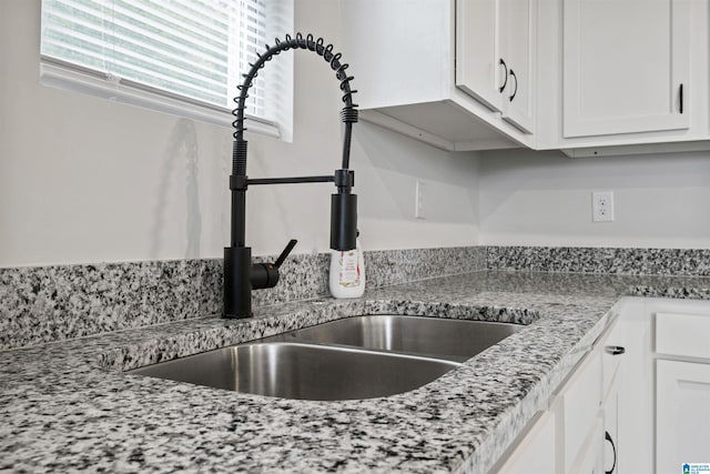 kitchen featuring a sink and white cabinetry