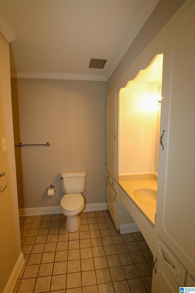 bathroom with crown molding, vanity, toilet, baseboards, and tile patterned floors