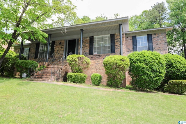 view of front facade featuring brick siding and a front yard
