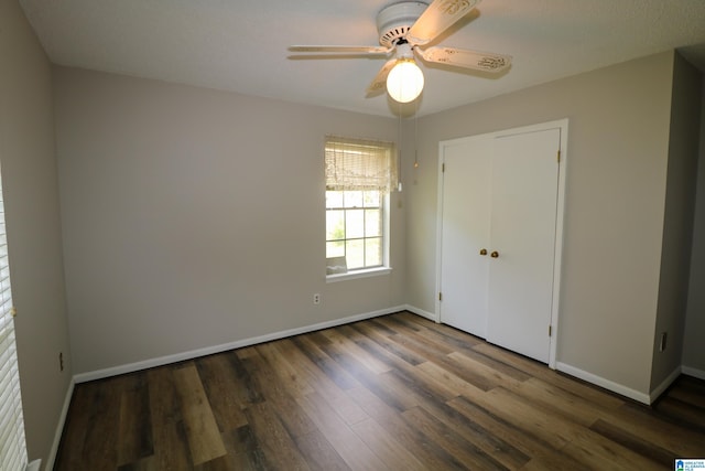 unfurnished bedroom featuring a closet, baseboards, a ceiling fan, and wood finished floors